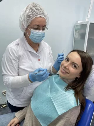 Лікарка оглядає пацієнтку в кабінеті Denta Lux
